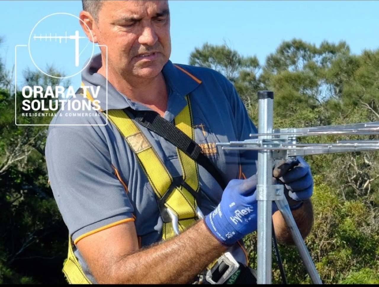 Nic from Orara TV Solutions adjusting a digital TV antenna on a Coffs Coast roof